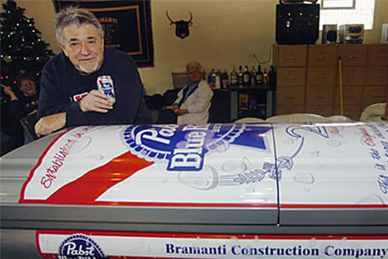 Bill Bramanti poses with a coffin he had specially made designed to look like a can of his favorite beer. (SouthtownStar via AP)