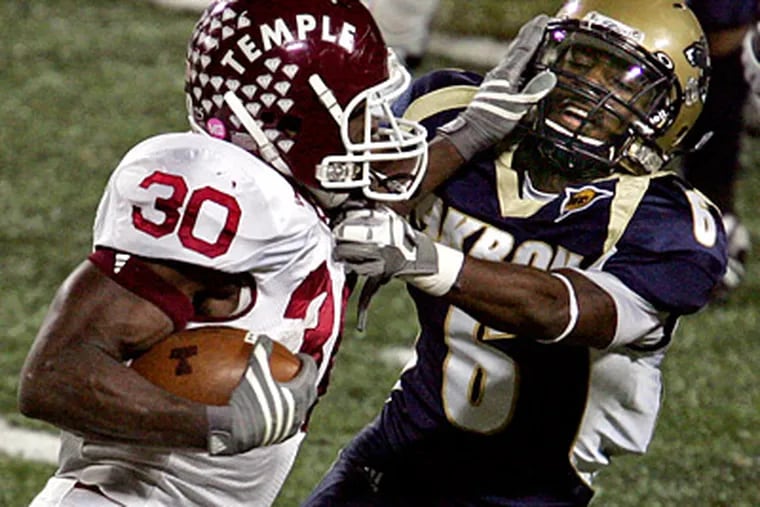 Temple's Bernard Pierce pushes past Akron's Manley Waller during the first half of Temple's 56-17 win yesterday. (AP Photo/Akron Beacon Journal, Ed Suba Jr.)