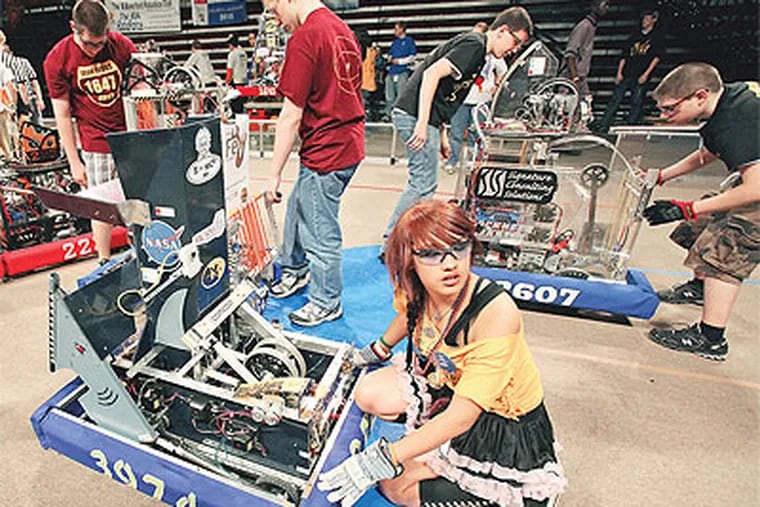 Kayla Resurreccion, a 10th-grader at Bishop McDevitt High School in Wyncotem gets her robot, Shark Byte, ready for a robotics competition Thursday at the Liacouras Center at Temple University. (Steven M. Falk / Staff Photographer)