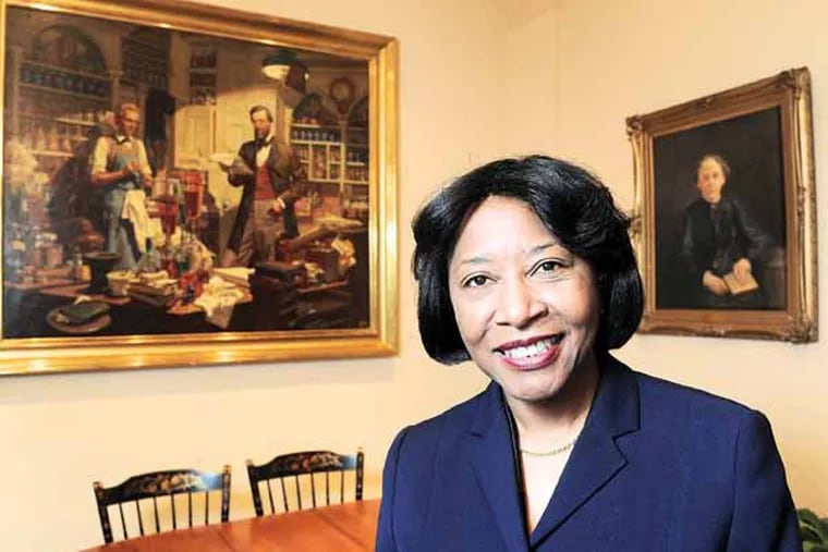 Portrait of Helen F. Giles-Gee, new president of The University of the Sciences, in her office March 21, 2013 flanked by a painting of an early apothecary and a portrait of the first female graduate of the school, Susan Hayhurst, who graduated in 1883.    ( CLEM MURRAY / Staff Photographer )