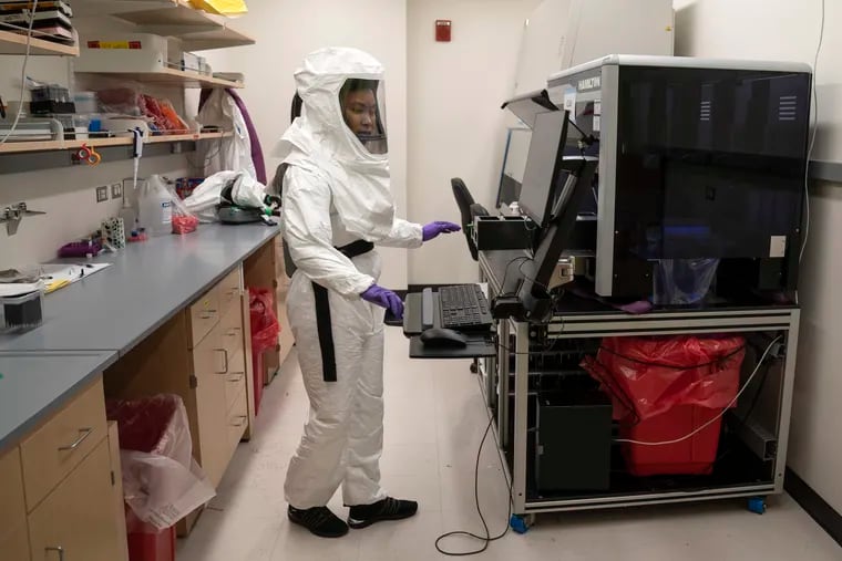 Lab assistant Tammy Brown dons personal protective equipment as she prepares positive coronavirus tests for sequencing to look for variants at the University of Maryland School of Medicine.