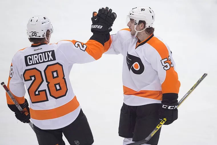 Flyers center Claude Giroux (28) and defenseman Shayne Gostisbehere (53) celebrate the power play goal by Gostisbehere against the Dallas Stars during the second period at the American Airlines Center.