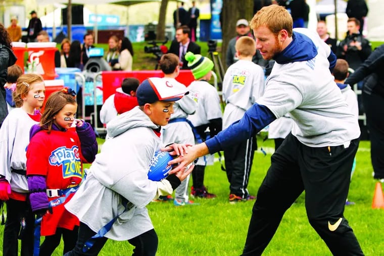 Carson Wentz hands off the ball during a 2016 NFL Play 60 event at Grant Park in Chicago.