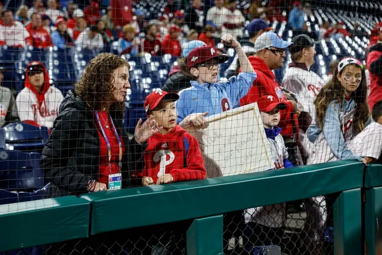 Kieran Goh 10, waits to see players before Game 2 of the National League Championship Series between the Arizona Diamondbacks and the Philadelphia Phillies on Tuesday. Kieran is pictured with his mom, Inquirer reporter Kristen A. Graham.