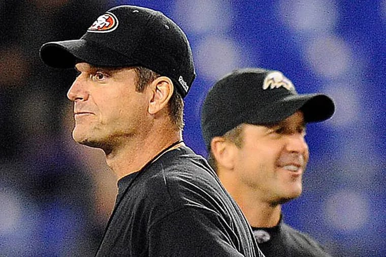 49ers head coach Jim Harbaugh, foreground, stands alongside his brother, Ravens head coach John Harbaugh, before an NFL football game. (Nick Wass/AP file photo)