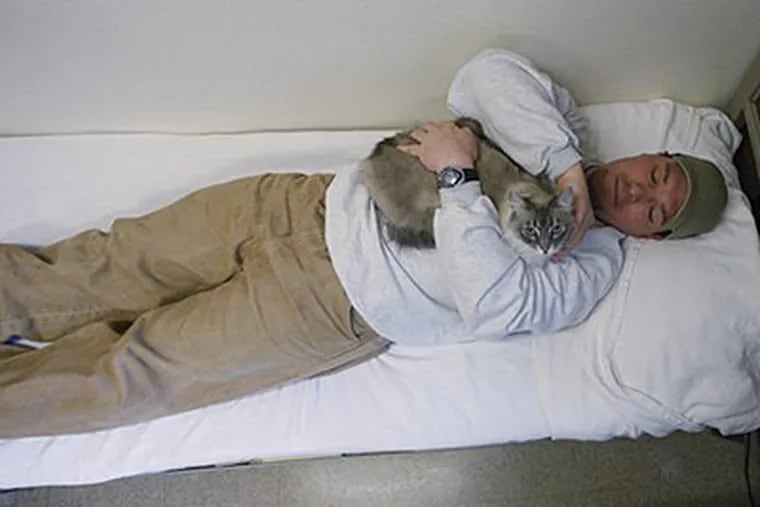 Inmate Richard Amaro holds Clementine in his 12-by-10-foot cell, which resembles a dormitory room, at Larch Correctional Facility Friday, April 20, 2012, in Yacolt, Wash. The Cuddly Catz program at the Larch Correctional Facility, a minimum-security prison is several months old, but inmates say they’ve already noticed a difference in the cats and themselves. The program began in cooperation with a local animal shelter. It has grown to include two cats and four inmates, and the prison plans to add four more cats. (AP Photo/Rick Bowmer)