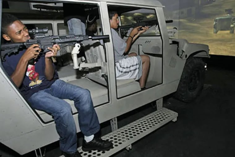 Bryon Clements (left), who is going into the Army, and Edwin Guzman, handle assault weapons in the "Armored Humvee" simulator  (Allejandro A. Alvarez/Daily News)
