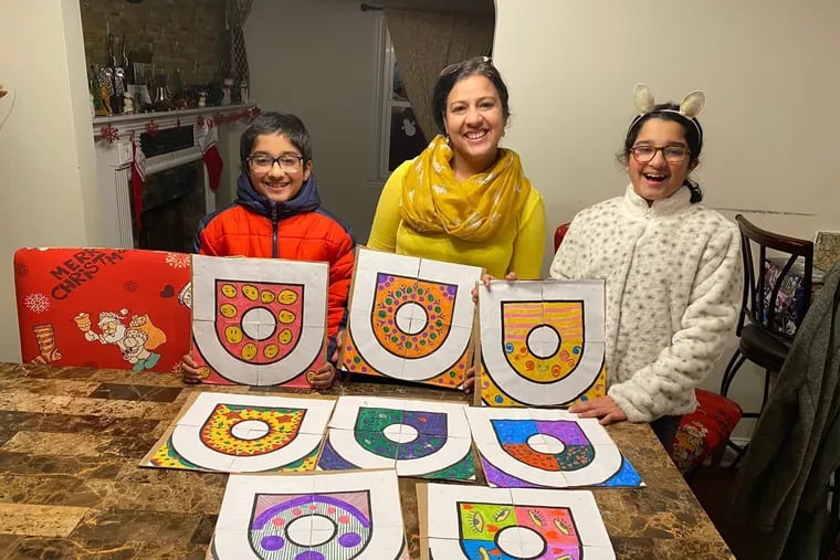 Anita Singh (middle) with son and daughter Adi Iyer (left) an Diya Iyer with their kolam designs. It began as a family activity over the holidays. She, her husband and their 9-year-old twins joined forces with five other families to create 35 tiles.