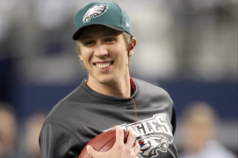 Eagles’ quarterback Nick Foles smiles while running with the football during warm-ups before the Eagles play the Dallas Cowboys on Sunday, December 29, 2013.