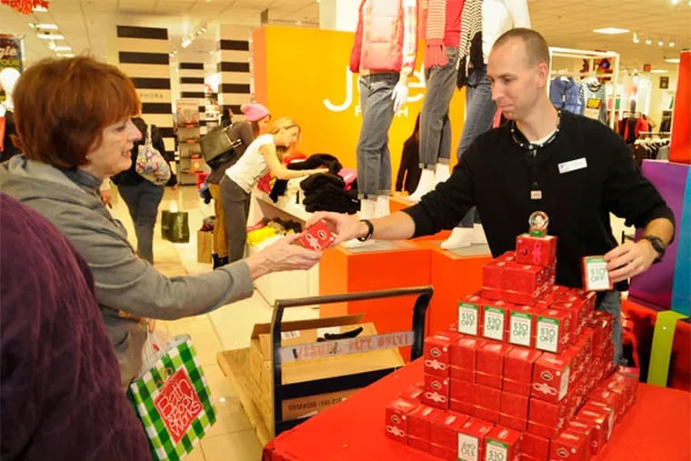 Ed Vandame of the J.C,Penney Co. store in King of Prussia hands out free snow globes on Black Friday, a Penneys tradition that had been stopped under now-ousted management. (Ron Tarver / Staff Photographer)