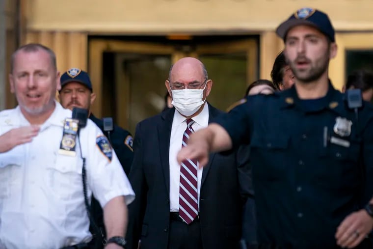 Law enforcement personnel escort the Trump Organization's former Chief Financial Officer Allen Weisselberg, center, as he departs court in New York.