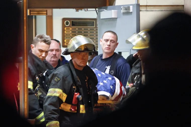 Fellow firefighters carry the body of fallen firefighter Capt. Michael Goodwin at Thomas Jefferson Hospital in Philadelphia, Saturday, April 6, 2013. The fire caused a partial roof collapse that killed Goodwin and injured a colleague who was trying to rescue him, officials said. (AP Photo/ Joseph Kaczmarek)