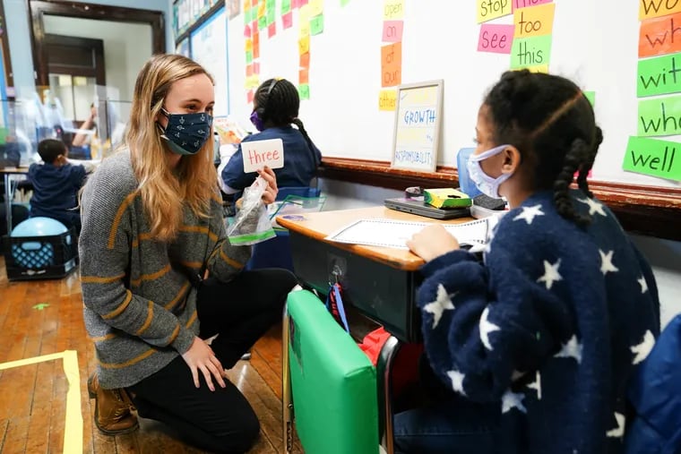 Student teacher Sophia Bonavolonta, left, works with reading flash cards with student Suhayla Stinette, 7, right, at Belmont Charter School, Thursday, February 25, 2021. Belmont Charter School started bringing K-2 students back to classrooms last week, this week it reopened for grades 3-5.
