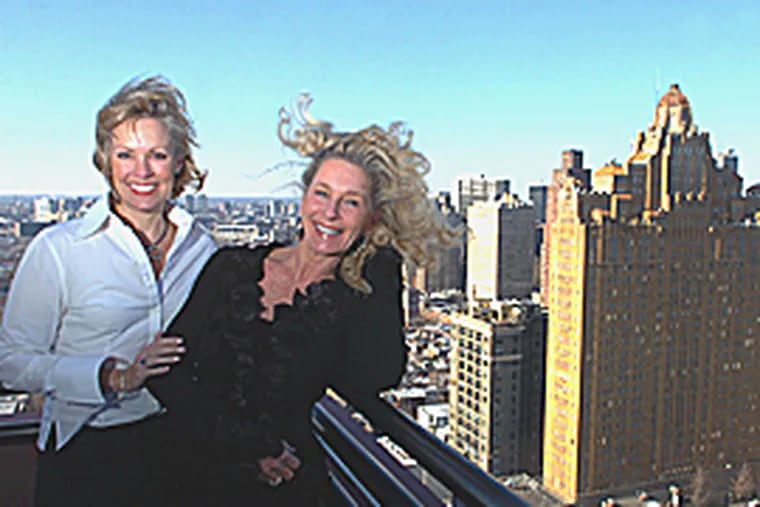 Interior designer Chere Onofrio (left) and Jane Miles atop Jane's condo balcony at Symphony House. Miles and her husband have an amazing north to south view. (Sarah J. Glover / Inquirer)