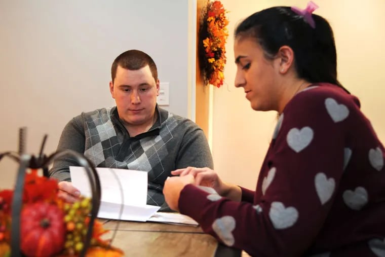 Gina and A.J. Auddino go through the mail in their South Philadelphia home after work. She has a college degree, he does not. More women with degrees are marrying working-class men without them.
