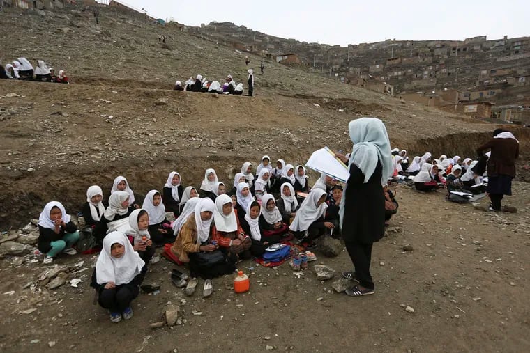 FILE - In this April 5, 2017 file photo, Afghan students attend school classes in an open air primary school on the outskirts of Kabul. But the Taliban has closed girls' schools in areas it controls, and only permitted the most rudimentary religious education for girls when it ruled Afghanistan.
