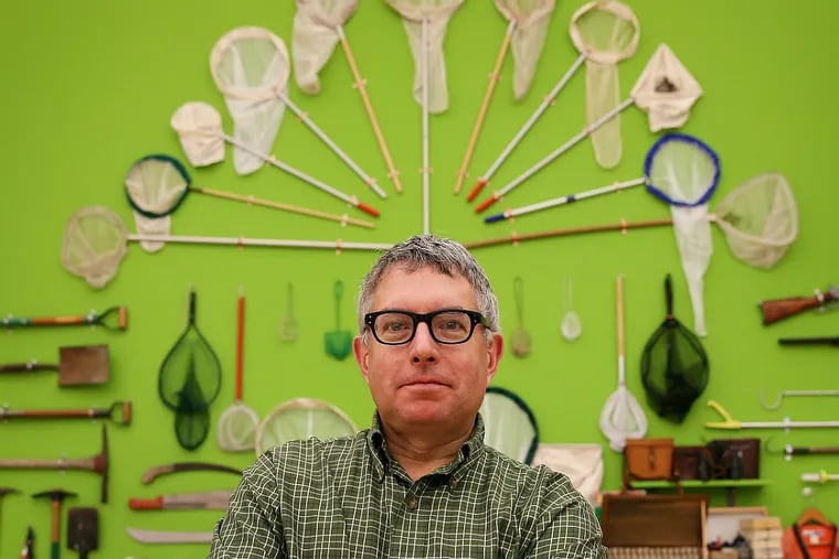 Artist Mark Dion stands before his symmetrical display of objects tied to natural history collecting. (David Maialetti/Staff Photographer)