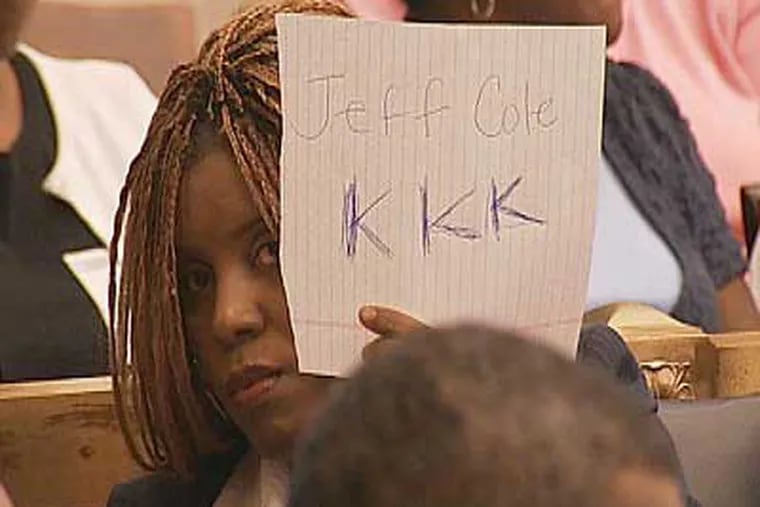 Latrice Bryant, an aide to City Councilman Wilson Goode Jr., holds a sign reading "KKK" directed at FOX29 cameras. (Image courtesy FOX29)
