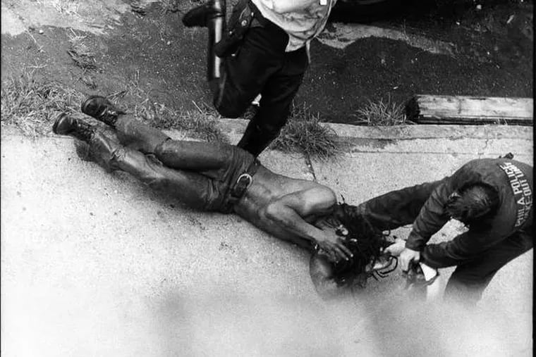In the first confrontation between police and MOVE, on Aug. 8, 1978, Officer James Ramp was shot and killed. His body and that of a wounded officer were removed. Here, Delbert Africa was kicked and beaten by police officers.