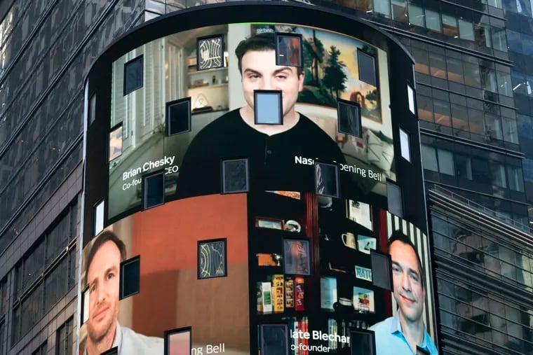 The electronic screen at the Nasdaq MarketPlace in New York displays the Airbnb co-founders Brian Chesky (top), Joe Gebbia (left), and Nathan Blecharczyk. The San Francisco-based online vacation rental company had its IPO Thursday.