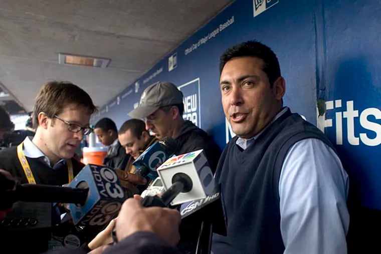 Ruben Amaro Jr., shown holding an impromptu press conference in the Phillies dugout in 2009, would love to return to the team.