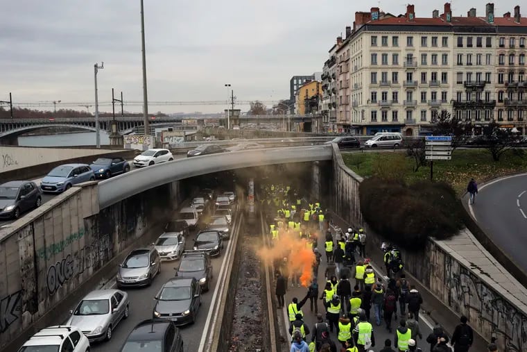 Demonstrators wearing yellow vests walk on the highway in Lyon, central France, Saturday, Jan. 5, 2019. Protesters were looking to breathe new life into the yellow vest movement as numbers of participants fell since the first Saturday protest in mid-November, prompted by the announcement of a national carbon tax.