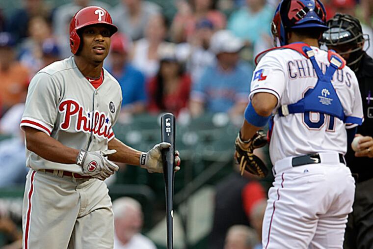 The Phillies' Ben Revere walks back to the dugout past the Rangers' Robinson Chirinos and home plate umpire Doug Eddings after striking out in the first inning. (Tony Gutierrez/AP)