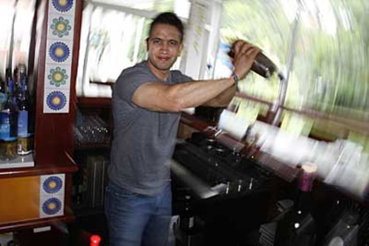 Andres Sanchez, at Positano Coast, mixes a drink he learned at the Liquid Lab in the Bronx. He was one of six Philadelphia bartenders schooled there. (MICHAEL S. WIRTZ / Staff Photographer)