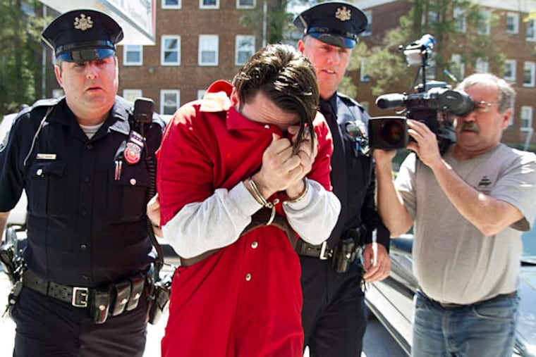 Neil Scott covers his face as he is led into a Montgomery County court yesterday. He has been in custody since February on other charges. (Clem Murray/Staff)