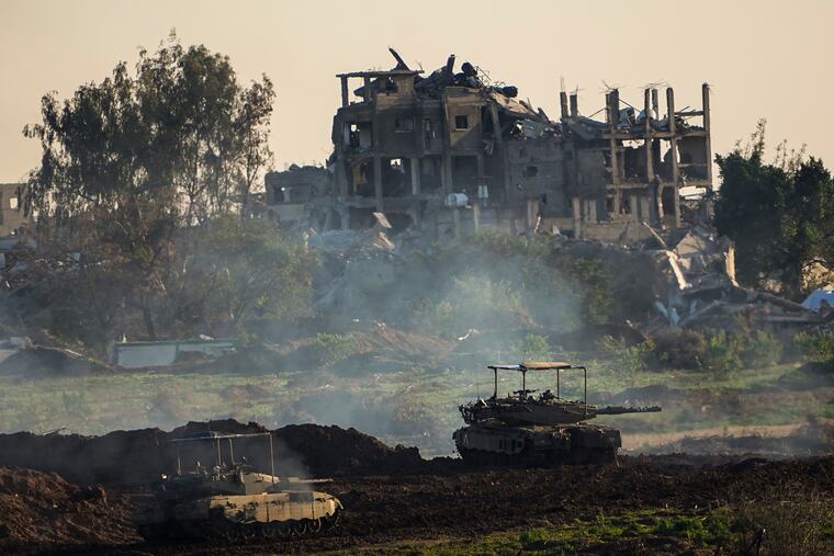 Israeli tanks are seen next to a destroyed building during a ground operation in the northern Gaza Strip on Friday.