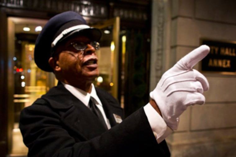 Leroy Mickens II hails a cab for a guest outside the Courtyard by Marriott hotel across from City Hall. MICHAEL PENN / For The Inquirer