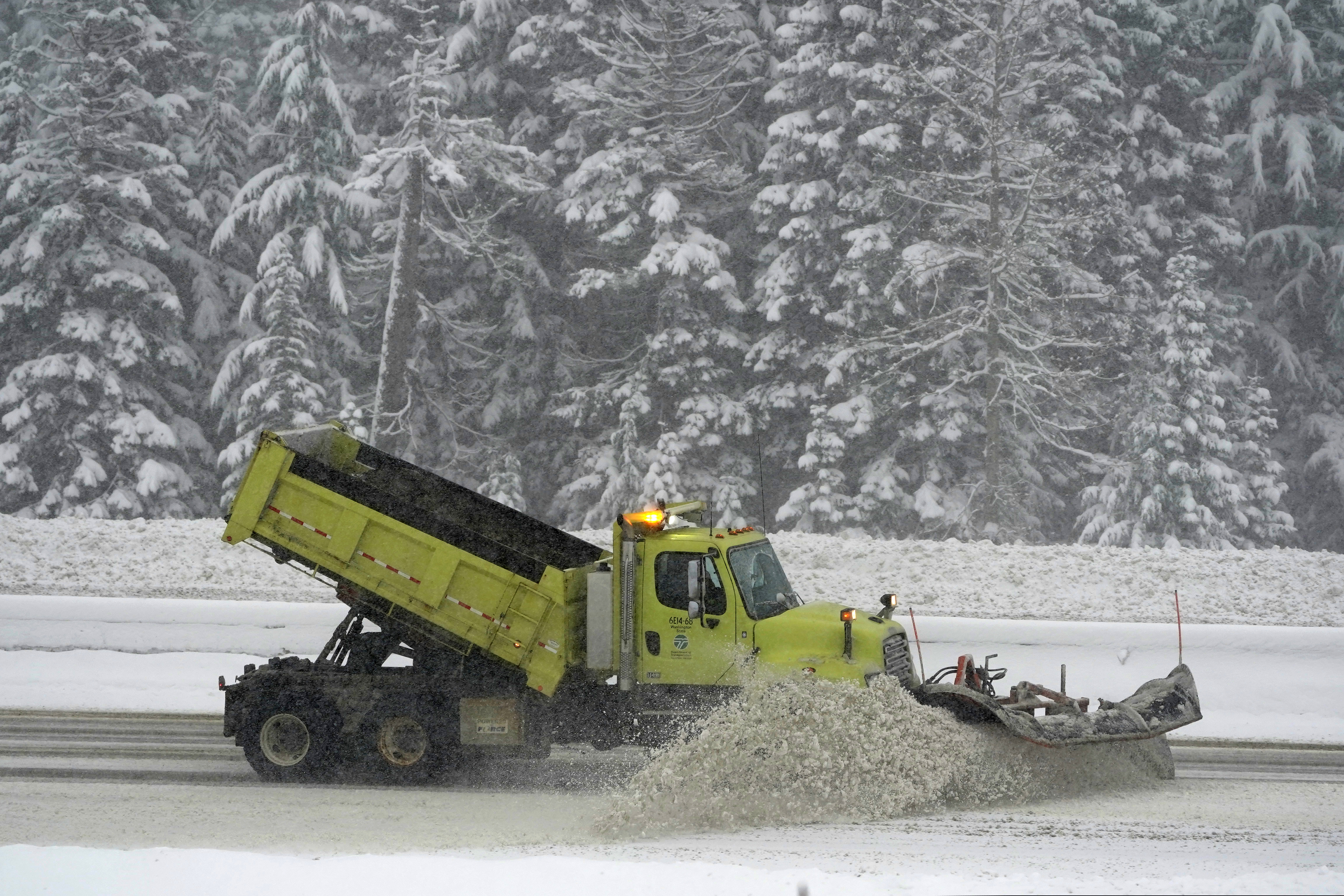 A Washington Dept. of Transportation snow plow works on a stretch of eastbound Interstate Highway 90 on Thursday as snow falls near Snoqualmie Pass.