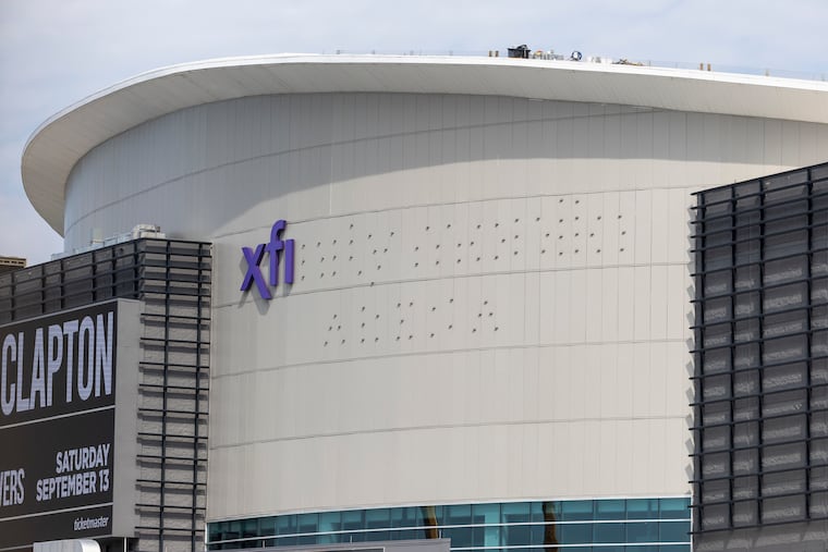 Workers putting up the Xfinity Mobile Arena signage on Thursday. The building had been known as the Wells Fargo Center since 2010.