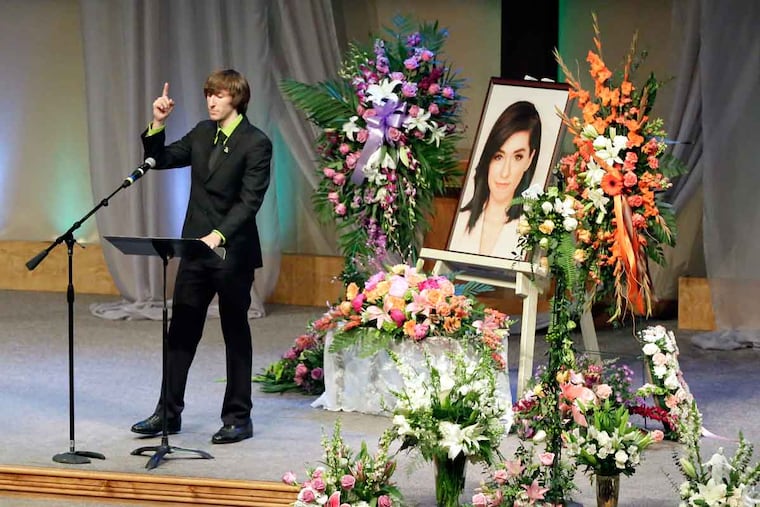 Marcus Grimmie gestures to a picture of his sister. Christina Grimmie was shot to death while signing autographs after a concert.