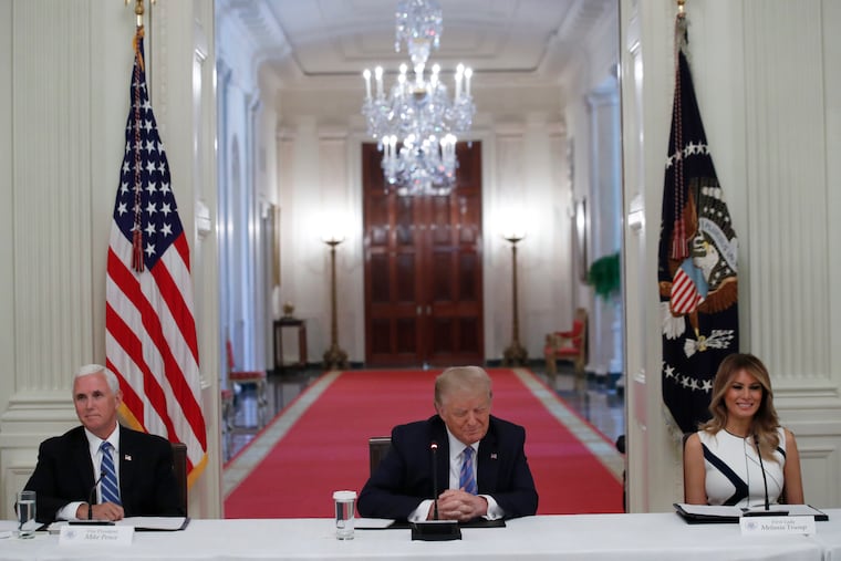 President Donald Trump, Vice President Mike Pence, left, and first lady Melania Trump, attend a "National Dialogue on Safely Reopening America's Schools," event in the East Room of the White House.
