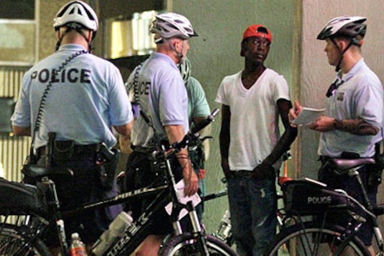 Police discuss Philly's new curfew laws with a young person last weekend. (Staff photo)