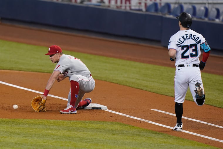 Rhys Hoskins (17) has to reach for a low throw at first base, which arrived in time to get Miami' Corey Dickerson (23) at first base during the first inning Wednesday, May 26, 2021, in Miami.