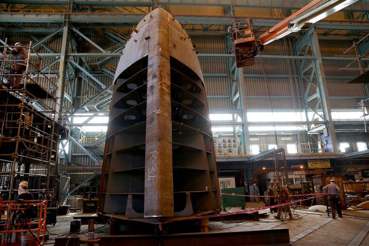 Workers assemble the bulbous bow section of a new 850-foot container ship at Philly Shipyard. The shipyard has no new orders to fill after the current ship is completed early next year.