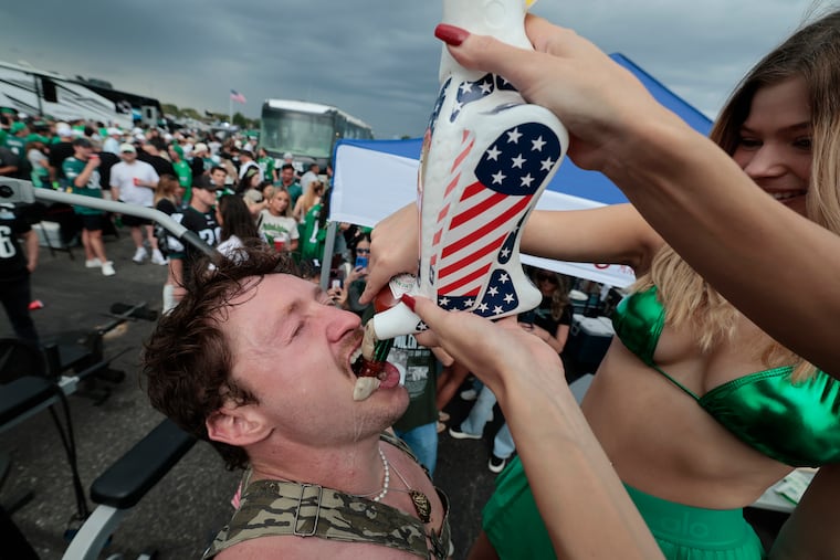 Ty the Hippie Meathead eats raw oysters from a funnel while Natalie Rodriguez pours hot sauce in his mouth during an Eagles tailgating party outside of Lincoln Financial Field on Sept. 4.