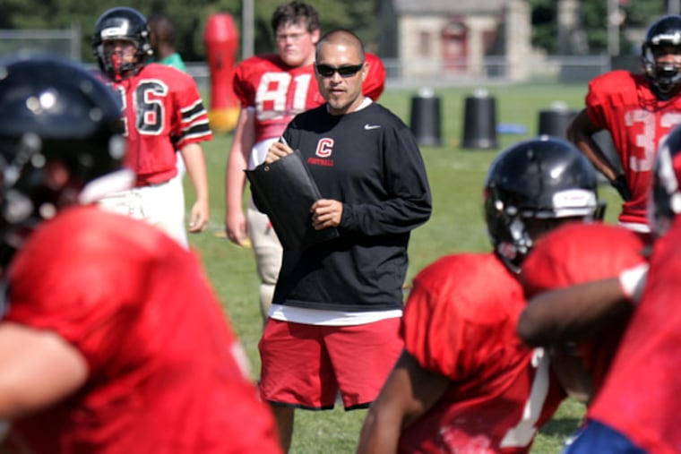 Coatesville football coach Matt Ortega (center) watches a play during practice.