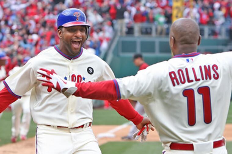 Ben Francisco is greeted by teammate Jimmy Rollins after scoring the game winning run. (Steven M. Falk/Staff Photographer)