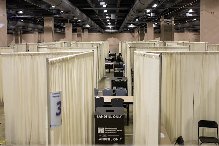 Workers clean up left over trash in the empty COVID Vaccine Clinic at the Philadelphia Convention Center after the city ended its partnership with Philly Fighting COVID.