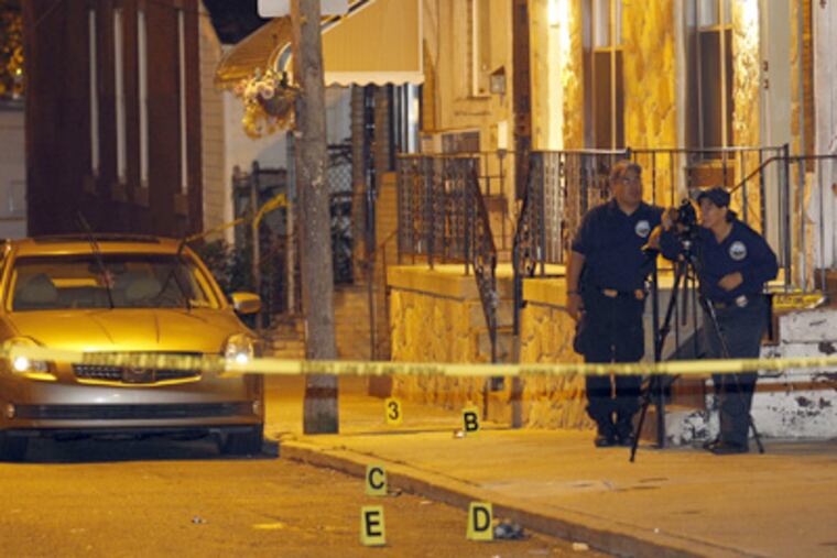 Police investigators photograph the scene of a multiple shooting on the 1200 block of Bucknell Street in South Philadelphia on Tuesday. (Yong Kim / Staff Photographer)