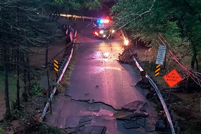 A police car is parked near the site where a pregnant woman and her 9-year-old son were swept away in a car to their deaths by flood waters in Berks County.