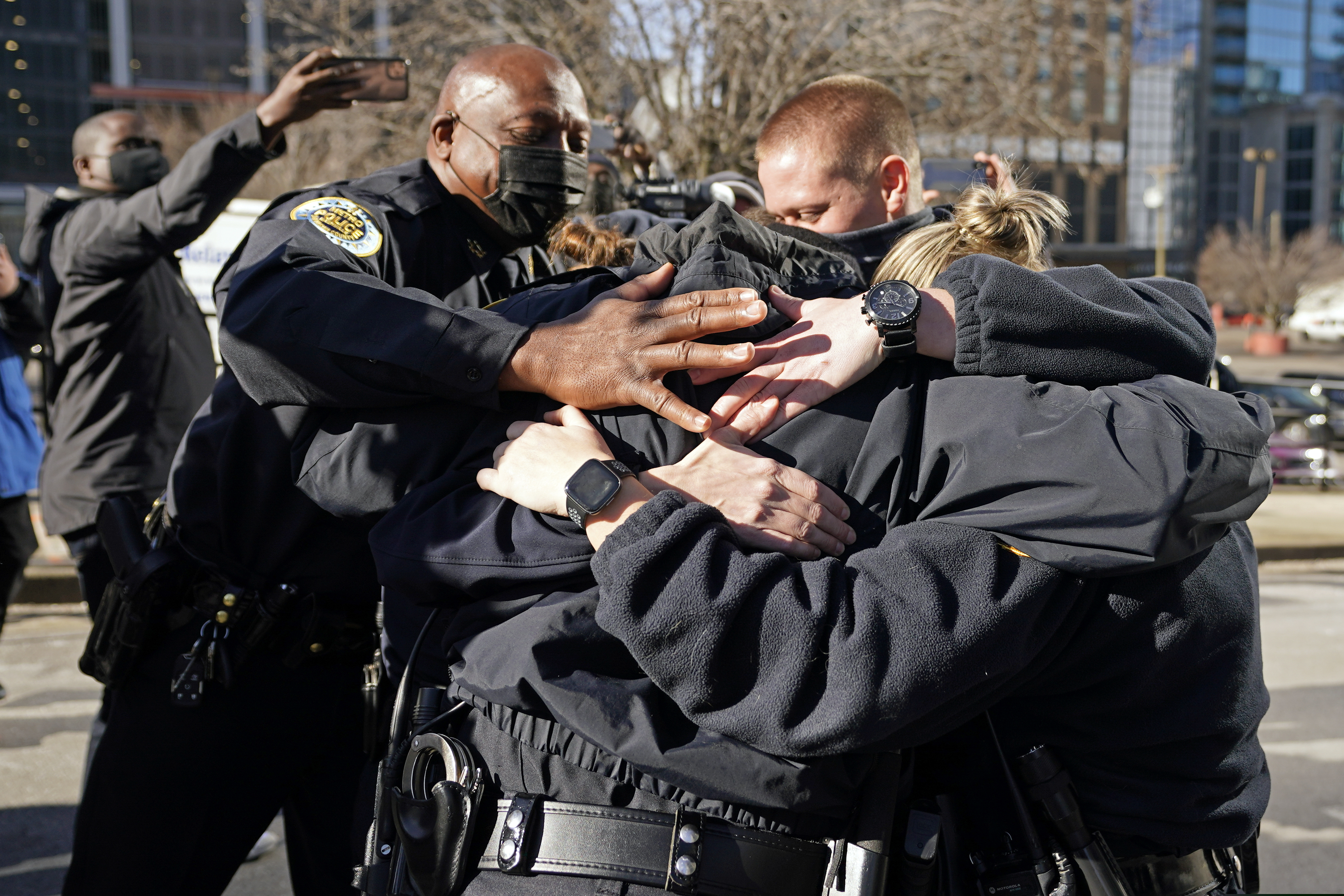 Nashville Police Chief John Drake, left, joined a group of police officers as they embraced after speaking at a news conference Sunday.