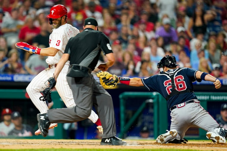 The Phillies' Bryce Harper steals home after getting past the tag of Braves catcher Stephen Vogt in the fifth inning Friday night.