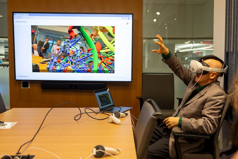 Troy Messick, a senior scientist at the Wistar Institute's Center for Advanced Therapeutics, tries out an interactive VR demonstration that lets you "step inside" a protein binding pocket and visualize drug interactions. The demonstration was part of the ribbon-cutting event for the new Center for Advanced Therapeutics.