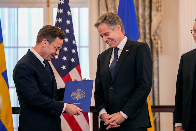 Secretary of State Antony Blinken, right, stands with Swedish Prime Minister Ulf Kristersson before presenting Sweden's NATO Instruments of Accession in the Benjamin Franklin Room at the State Department on Thursday in Washington.