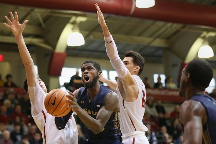 La Salle's B.J. Johnson (20) puts the ball up past Saint Joseph's Taylor Funk (33) and Pierfrancesco Oliva (24) during a game at Hagan Arena on Saturday, March 3, 2018. Saint Joseph's won 78-70. TIM TAI / Staff Photographer