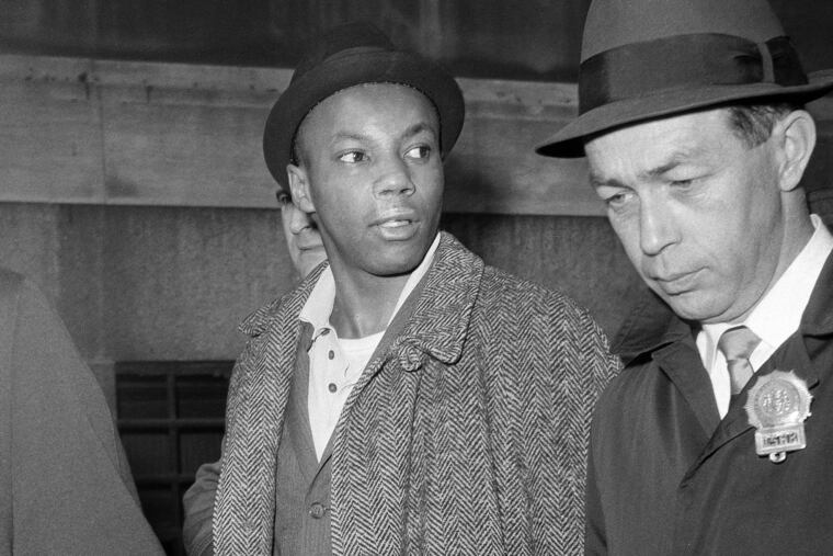 Norman 3X Butler (left), 26, a suspect in the slaying of Malcolm X, being escorted by detectives at police headquarters after his arrest in New York on Feb. 26, 1965.